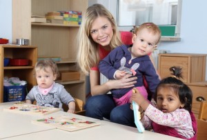 Erzieherin am Tisch mit Kinder beim Puzzeln